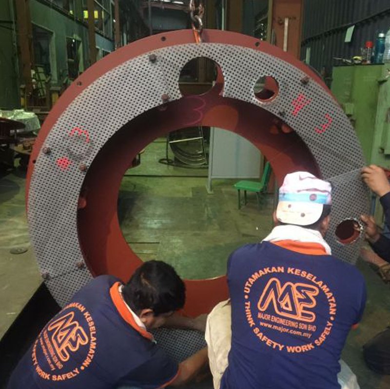 Technicians inspecting a large ring in the workshop