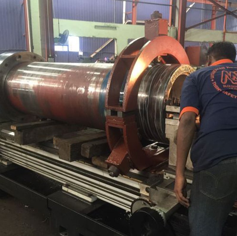 Crew machining a large shaft on the workshop lathe